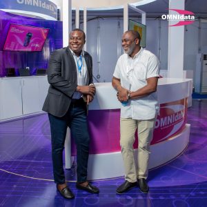 Dois homens em frente a Stand da Omnidata, montado pela impaktu digital para melhoria da comunicação visual e publicidade da marca