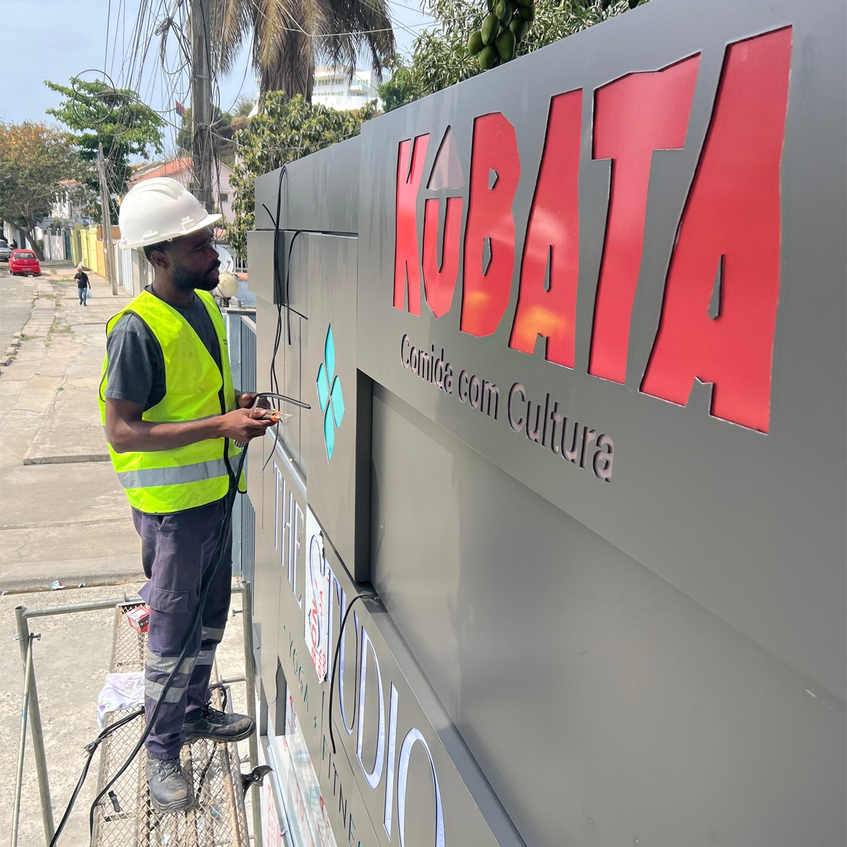 Técnico da Impaktu Digital revestindo o exterior de uma edifício com Alucobond para a empresa Kubata, para melhoria da comunicação visual e publicidade da marca